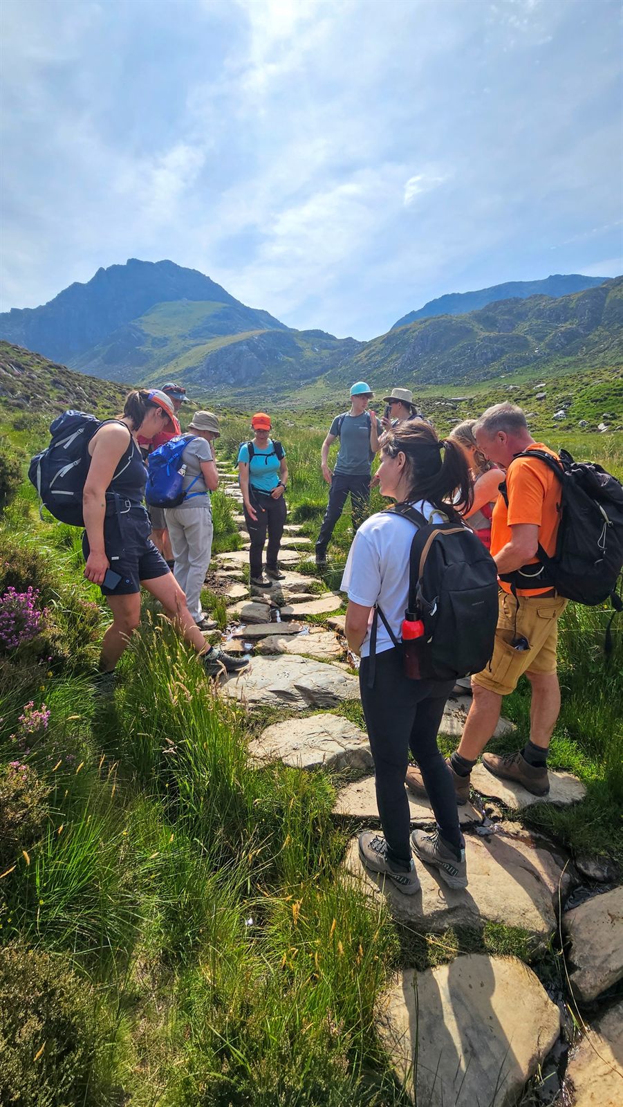 A walking group on a stone path at Cwm Idwal